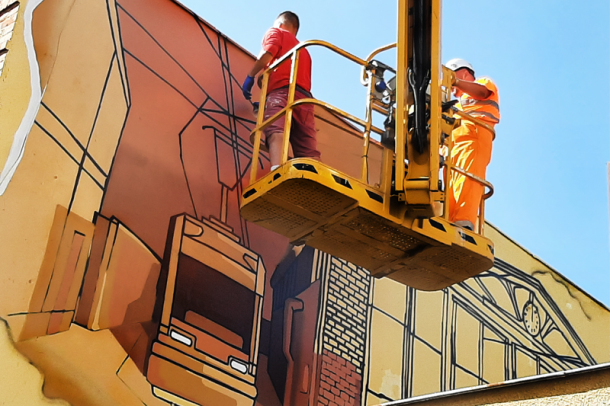 Artysta maluje mural na ścianie