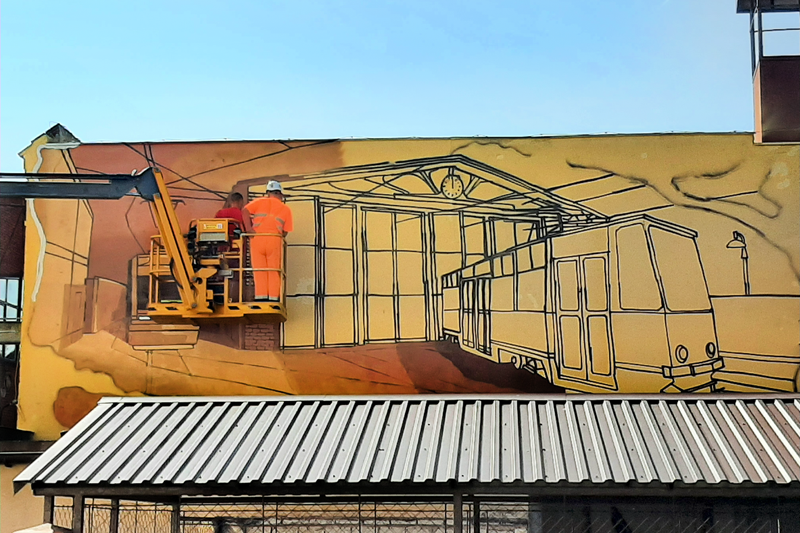 Artysta maluje mural na ścianie