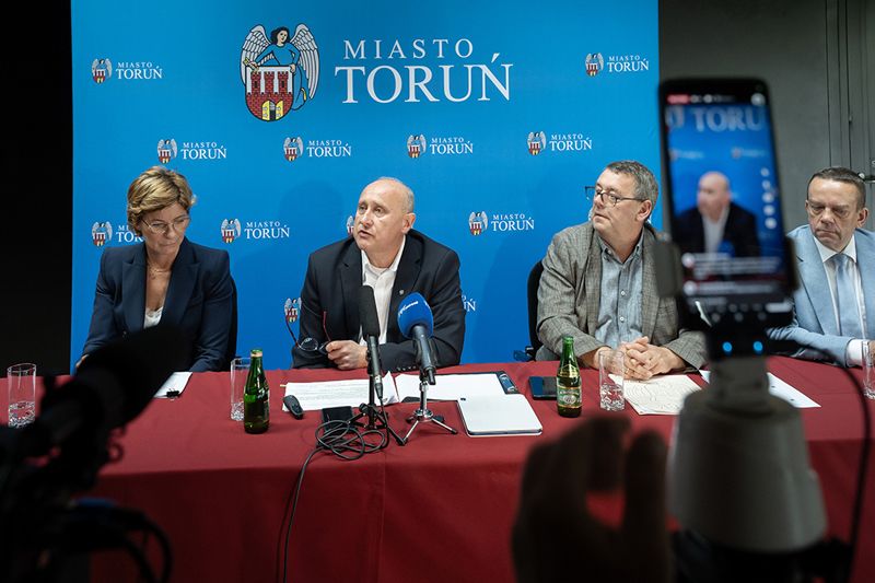 Konferencja prasowa osoby za stołem prezydialnym