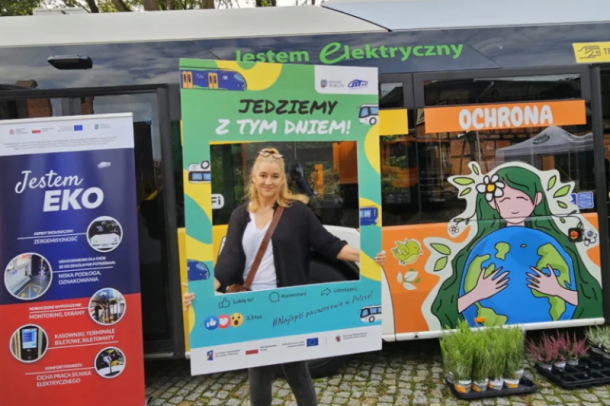 Kobieta na tle ekologicznego autobusu elektrycznego