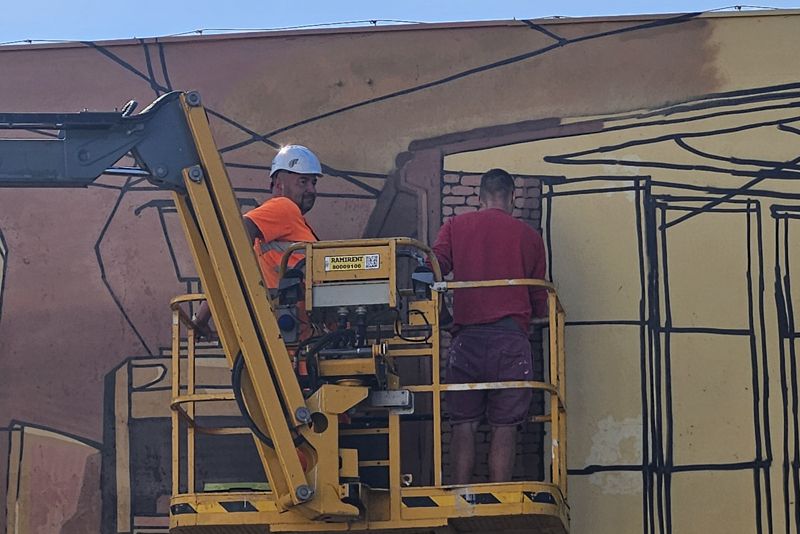 Artysta maluje mural na ścianie